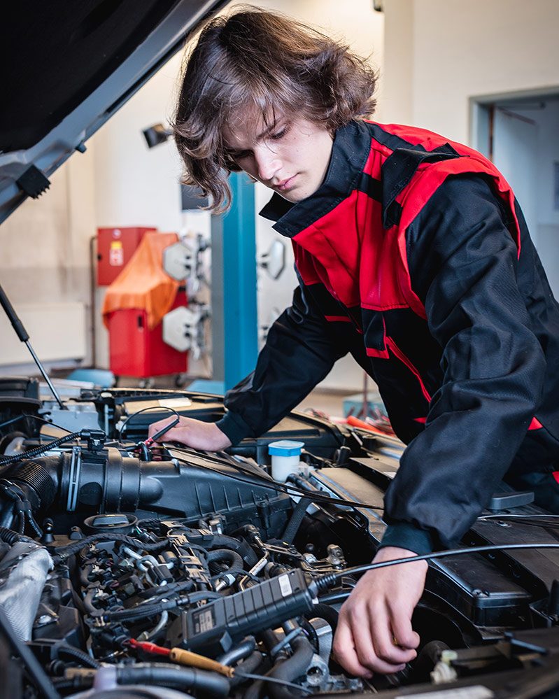 student opravuje auto